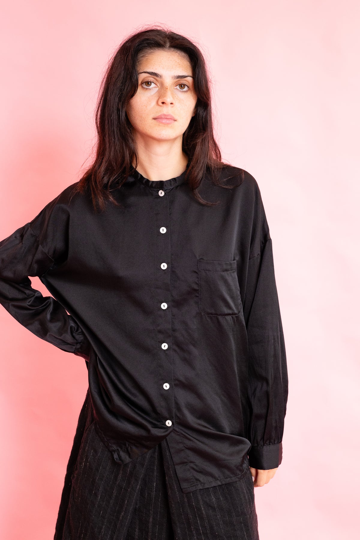 model wearing a black silk collarless shirt