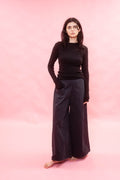 Person wearing a black outfit on a pink background