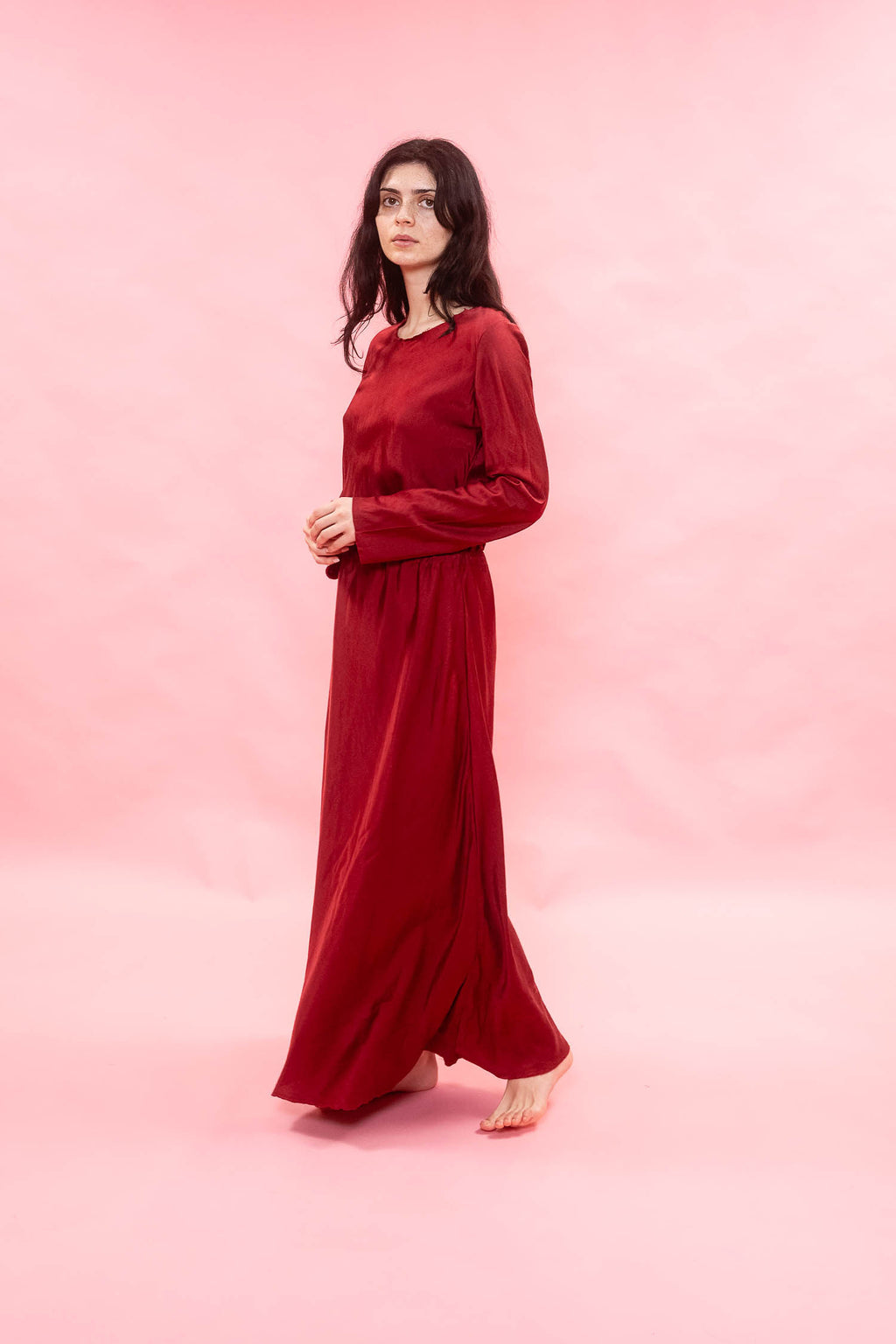 Woman wearing a red dress against a pink background
