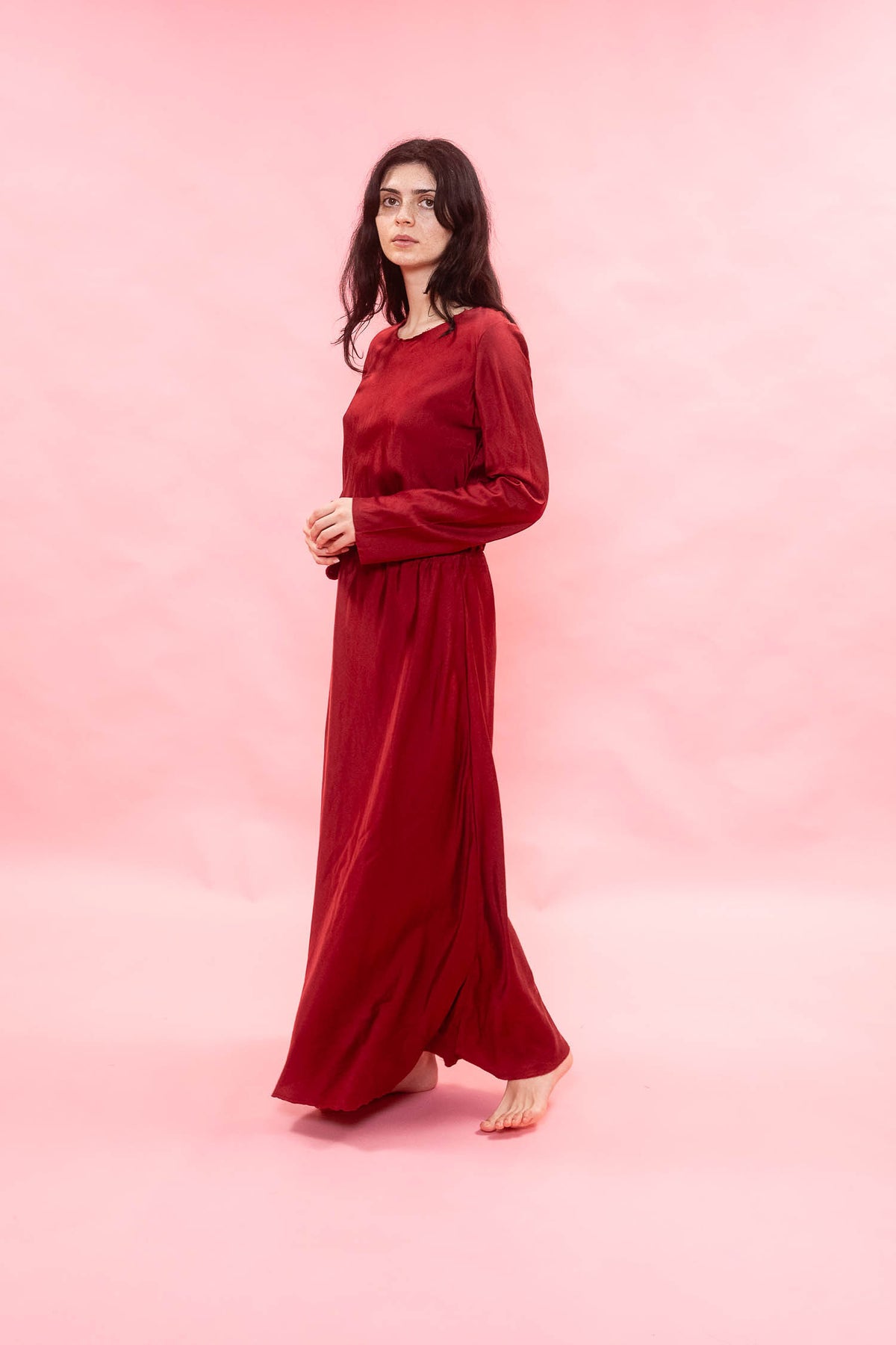 Woman wearing a red dress against a pink background